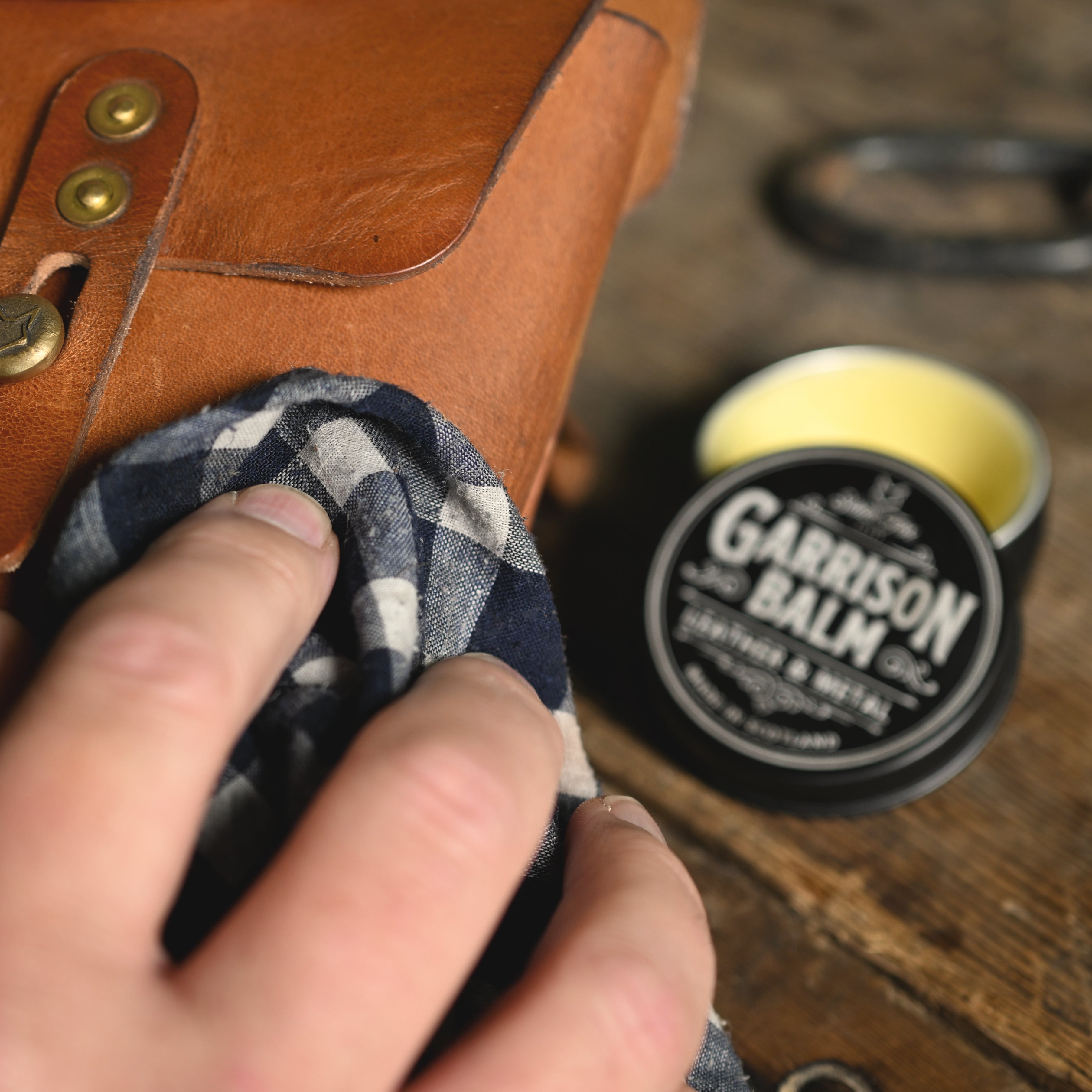 Applying Garrison Balm to a leather pouch with a rag