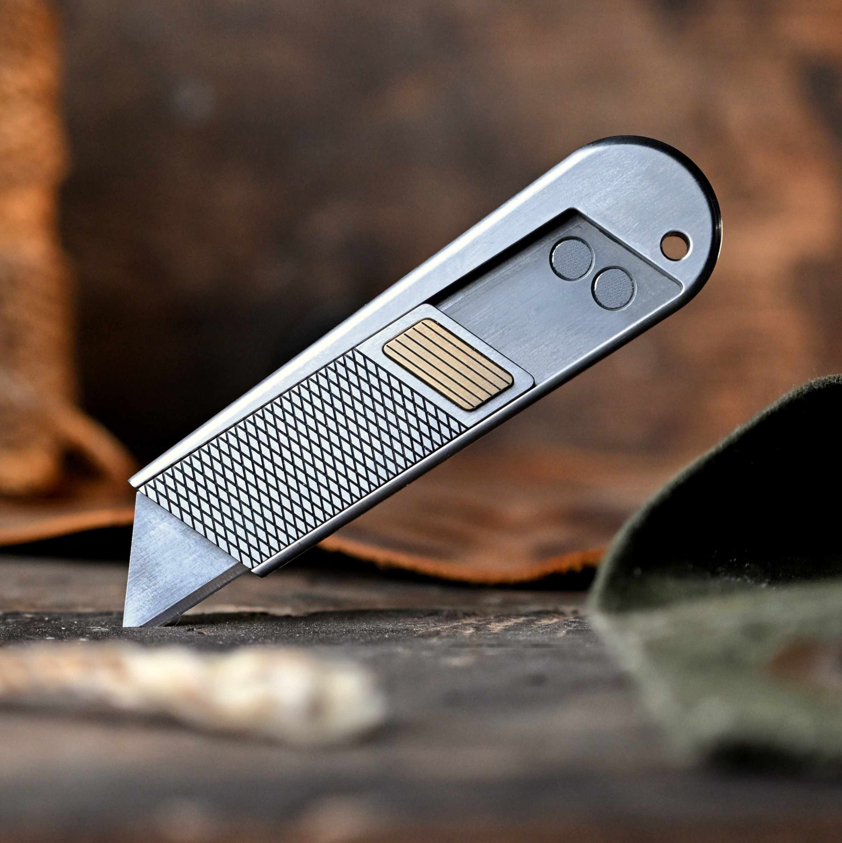 Small pocket knife on a wooden surface with twine and leaves